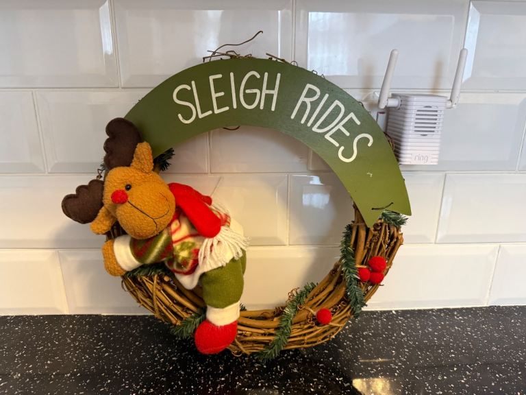 Reindeer Christmas wreath featuring a plush Reindeer figure and a "Sleigh Rides" sign 14" 