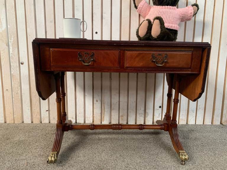 Vintage Reproduction drop-leaf Pembroke table with a leather top and brass claw feet.
