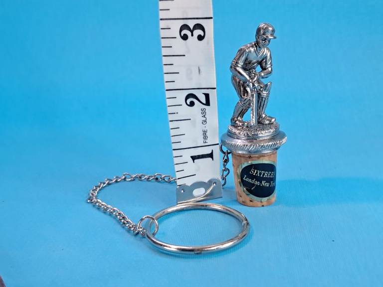 Vintage cricket-themed bottle stopper potentially a collectible item..