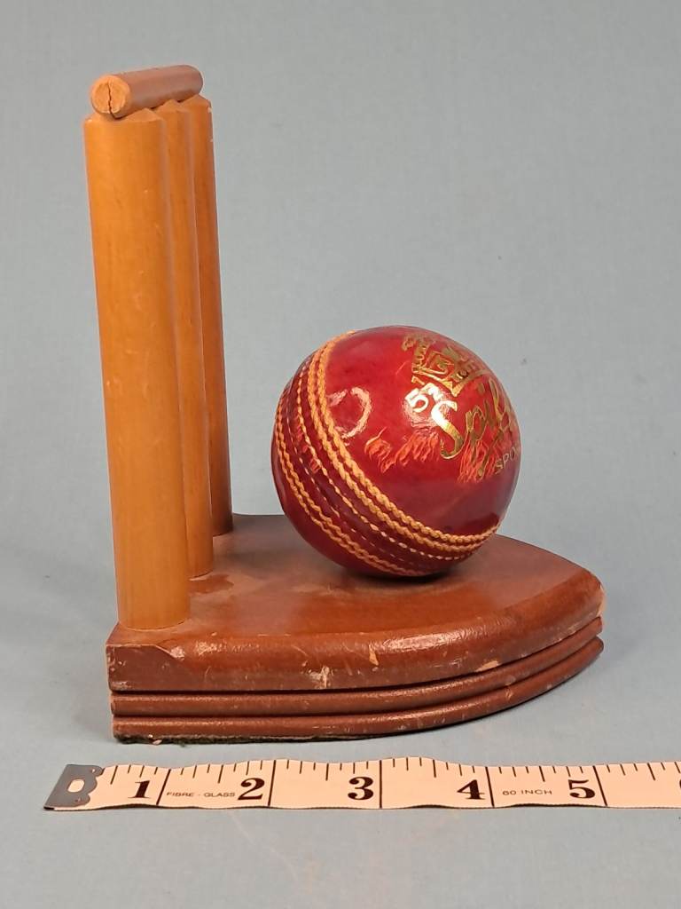 Vintage cricket ball and wicket bookend. 