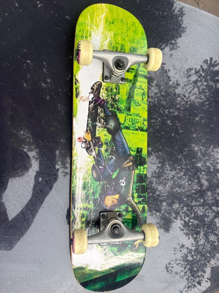 Skateboard with Green and Black Graphic Deck – Good Condition