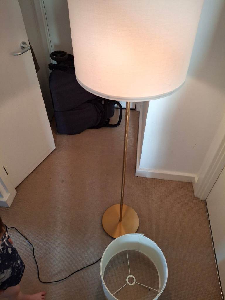 IKEA SKAFTET standard lamp in a brassy/gold finish.