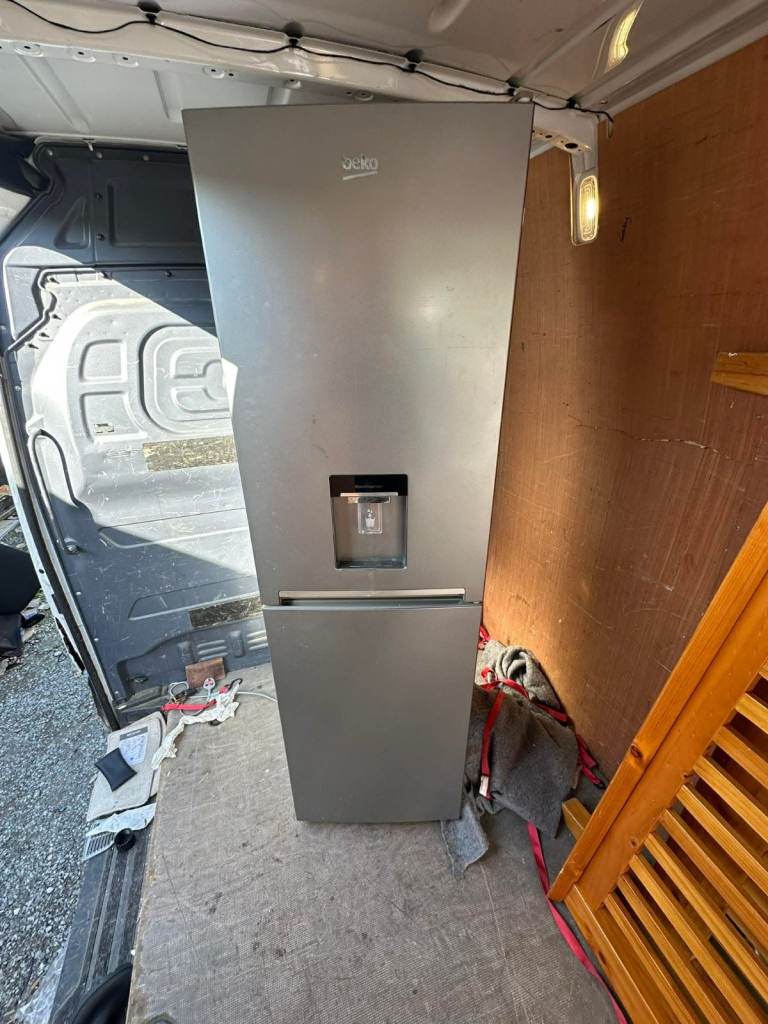Beko fridge freezer, silver in colour, with a built-in water dispenser on the door.