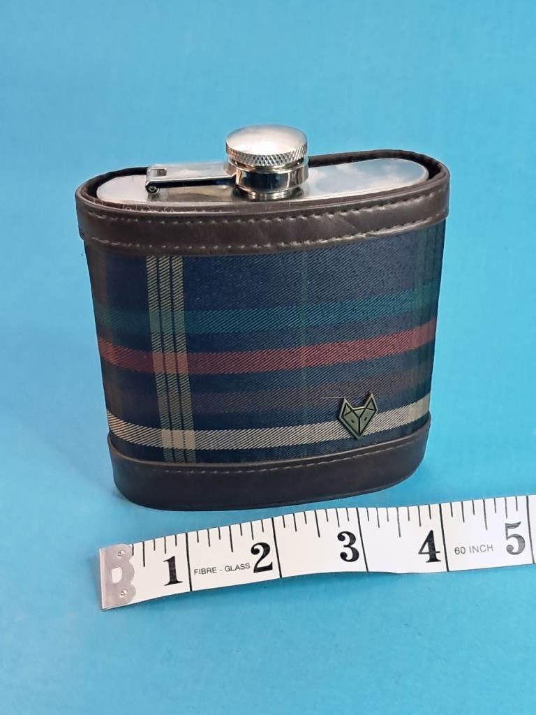 stainless steel hip flask wrapped in a blue tartan fabric with stitched leather trim.