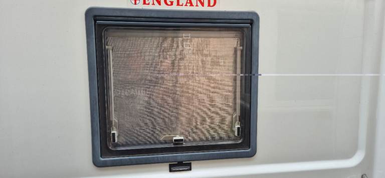 Windows with frames, blinds and flynet for van conversion.