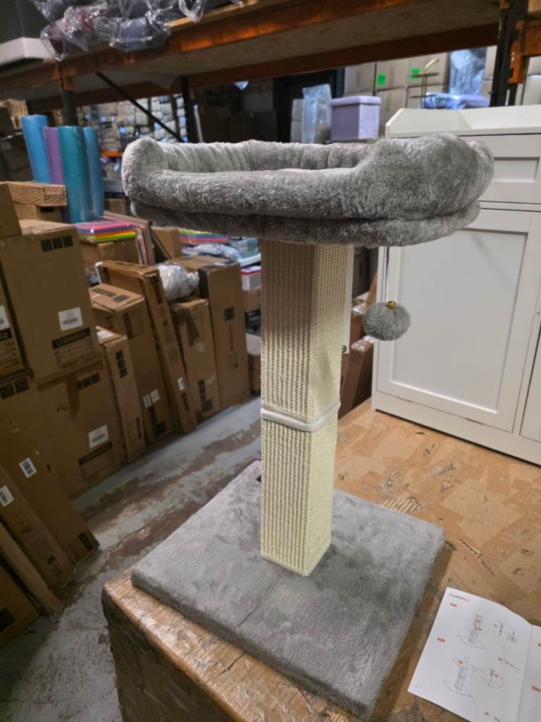 A new cat scratching post with ball with a bell and a bed at the top 
