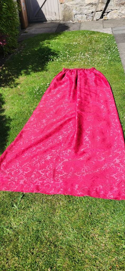 Pair of red curtains with tie backs and hooks