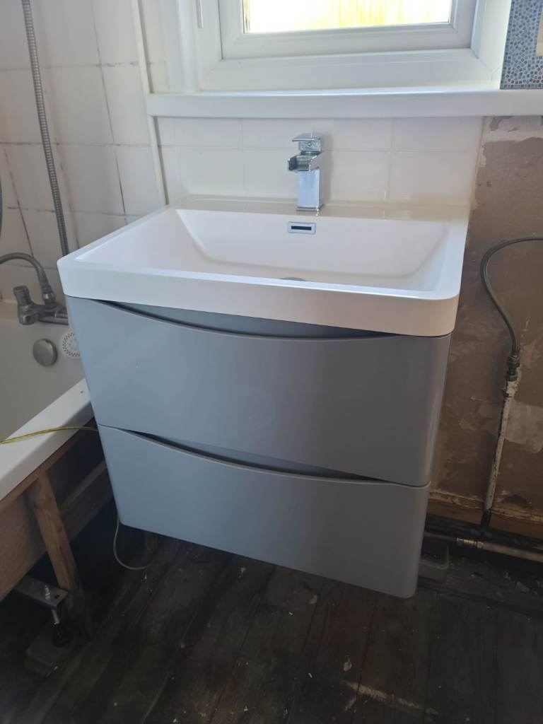 Grey gloss wall hung vanity unit with sink and taps