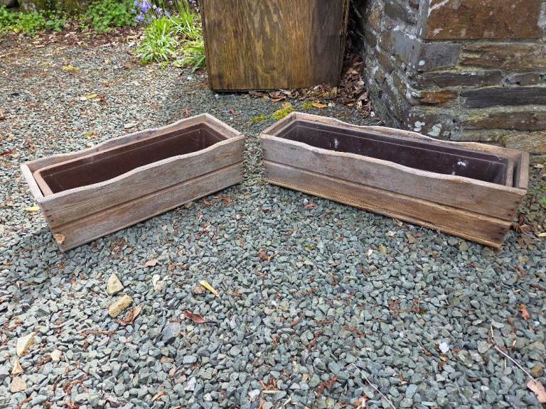 2x wooden planters with plastic pots