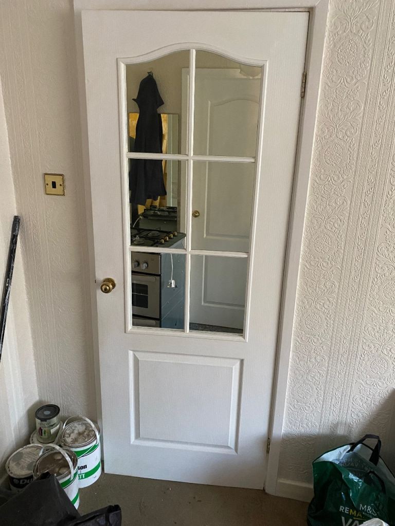 Internal glazed panel door including handles and hinges.