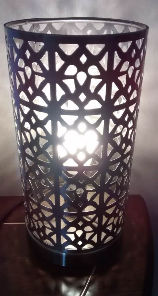 Bronzy coloured cylindrical metal perforated table lamp