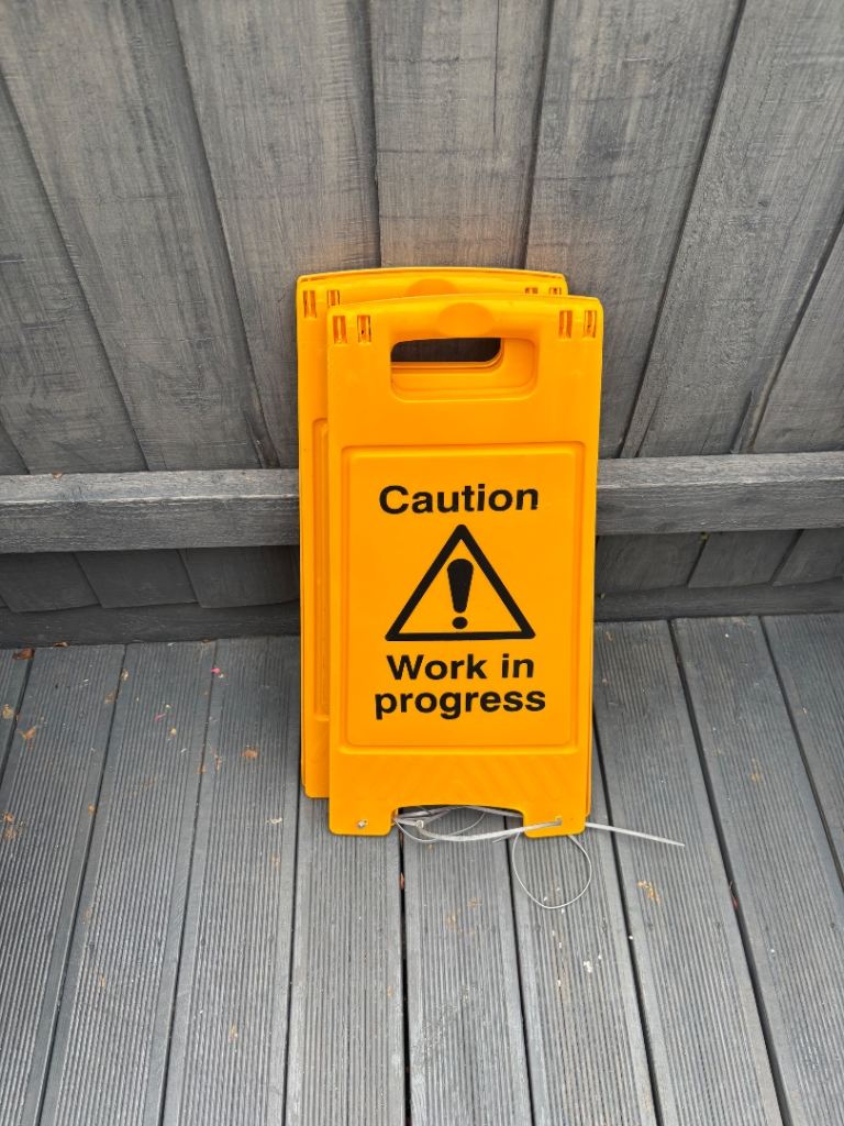 Two Yellow 'Caution Work In Progress' Safety Signs