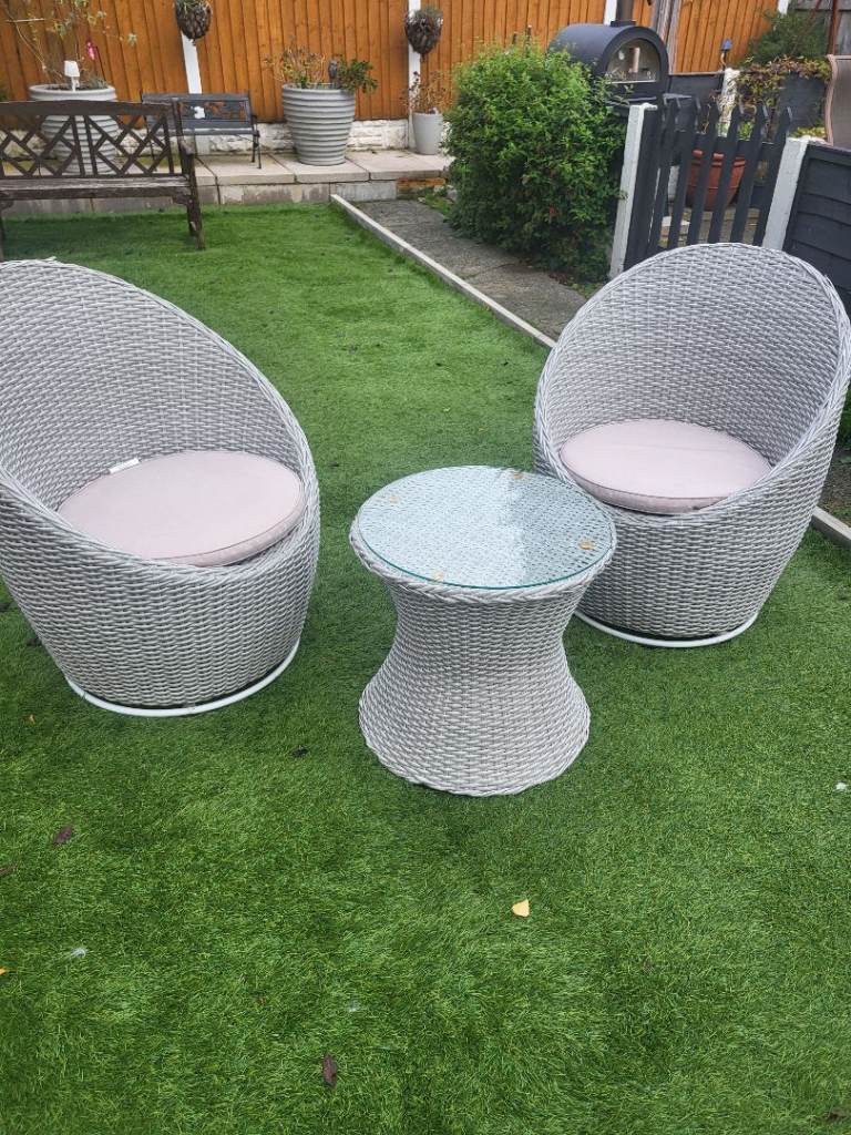 Two wicker swivel chairs with table 