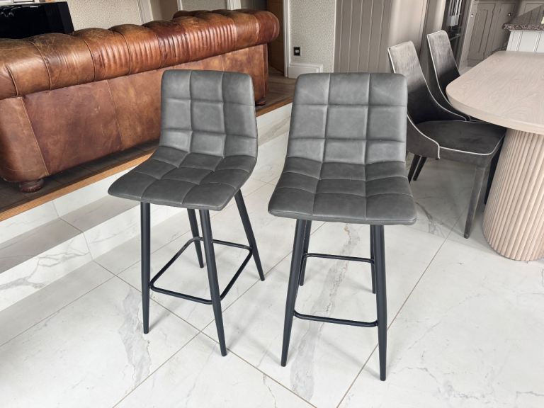 Two faux leather Costco grey bar stools 