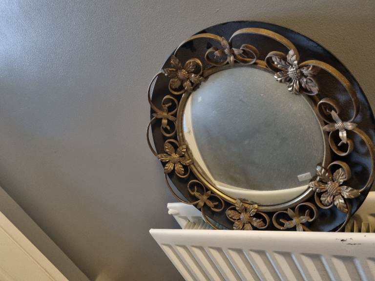 Vintage convex butler's mirror, black metal frame with gold-coloured floral and leaf design 