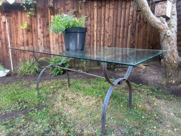 Glass top garden table with cast iron frame 