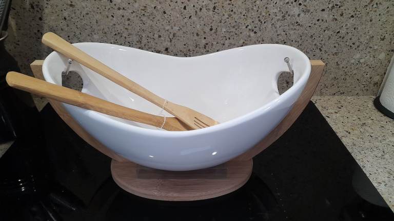 Ceramic salad bowl on wooden stand