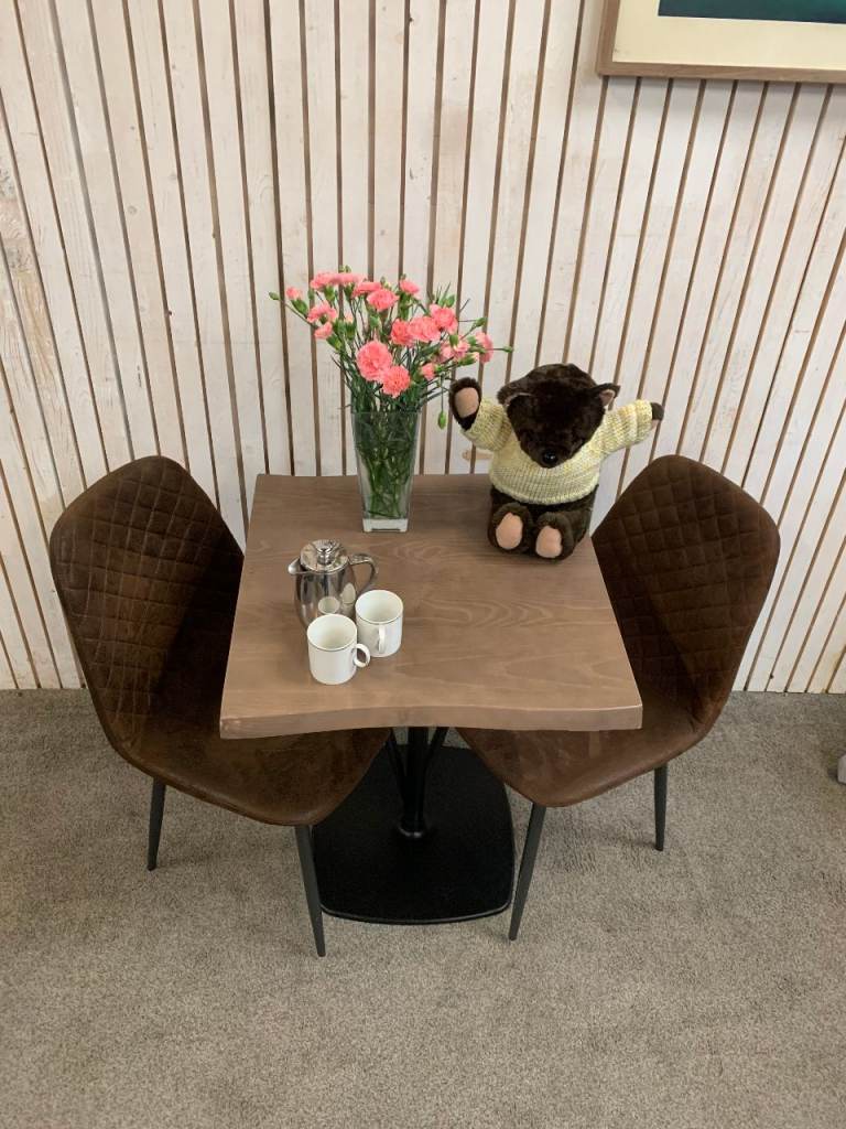 Bistro Dining Table with two Chairs, featuring Square Brown Faux-Suede Seats .