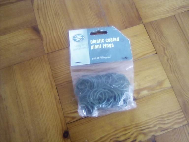 New, unopened pack of 100 plastic coated garden plant rings.