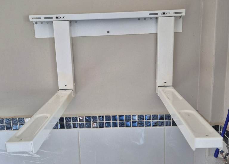 white wall-mounted microwave oven bracket with extendable arms.