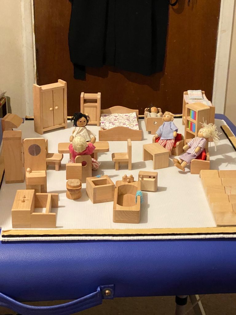 A wooden dollhouse furniture and family set.