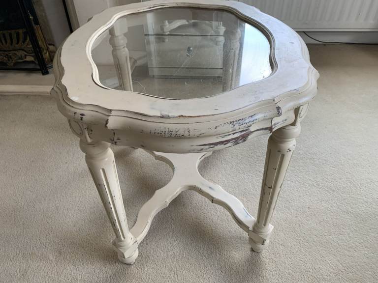 A sturdy  side/coffee table in a manufactures 'distressed cream finish' with built in glass top.