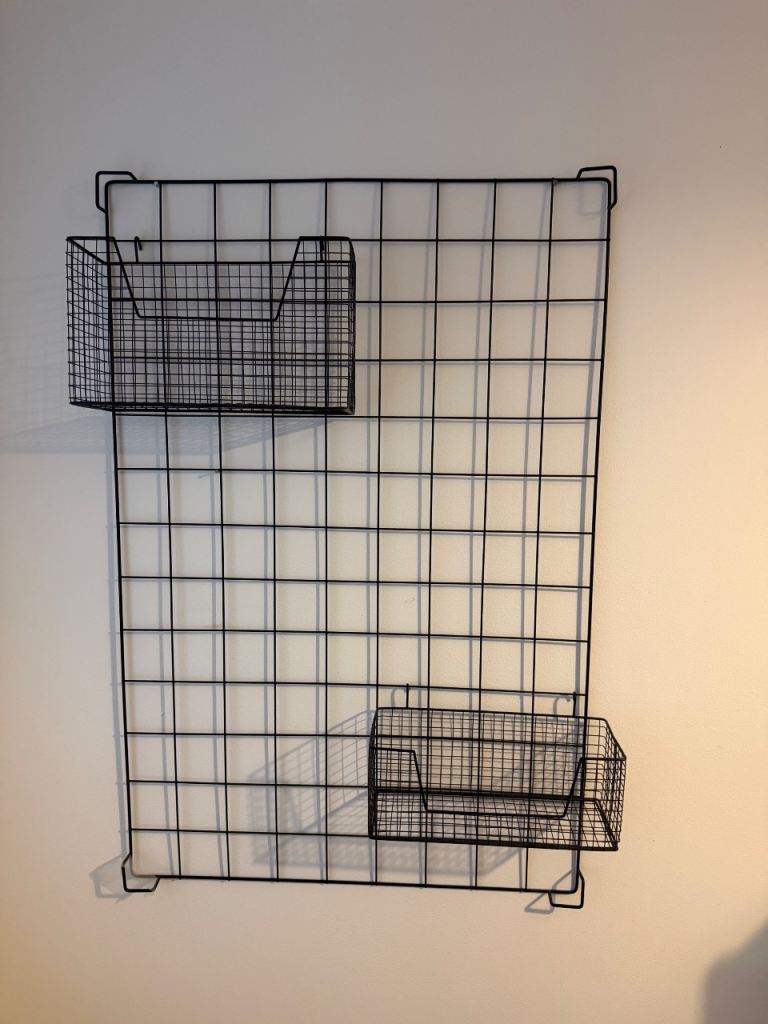 Black industrial rustic style metal wall grid with movable storage shelves 