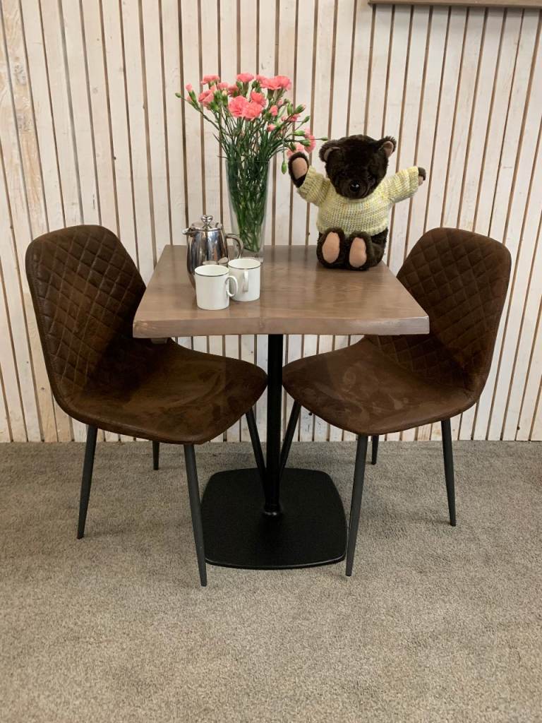 Bistro Dining Table with two Chairs, featuring Square Brown Faux-Suede Seats .