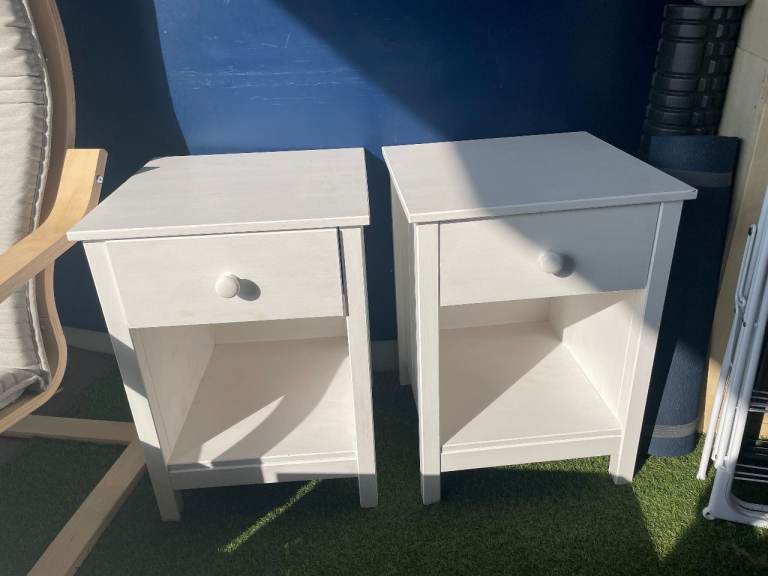 Two white bedside tables with one drawer each.