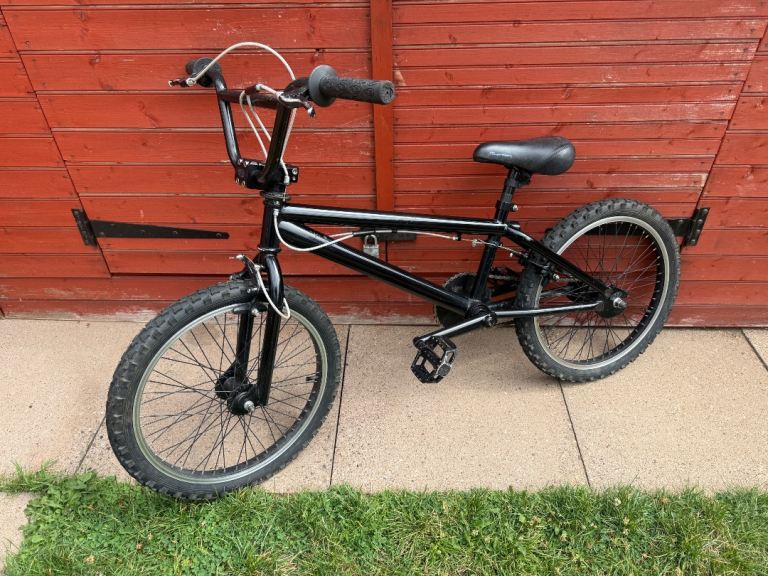 Black 20” wheeled BMX.