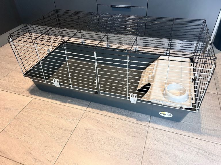 Pet cage with plastic base, wire top, and accessories