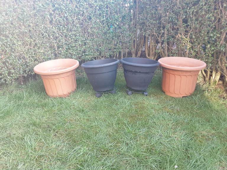 4 X LARGE PLANT POTS & 2 x WHEELED STANDS
