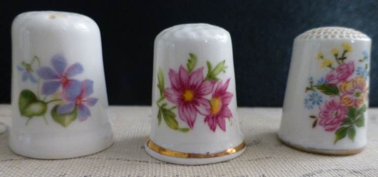 Three bone china thimbles with floral pattern decoration