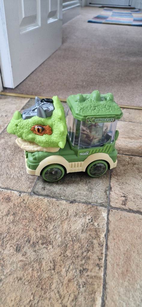 ELECTRIC DINOSAUR TRUCK. INCLUDES BATTERIES. VERY GOOD CONDITION.
