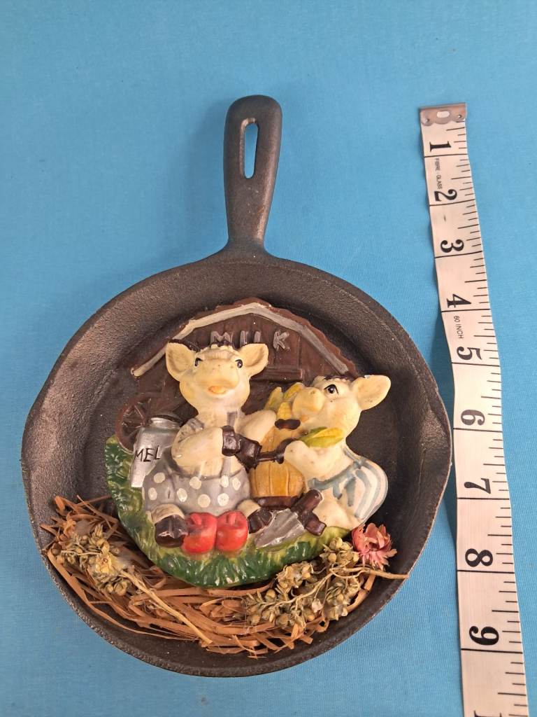 Vintage decorative cast-iron hanging ornament that features two small pigs. 