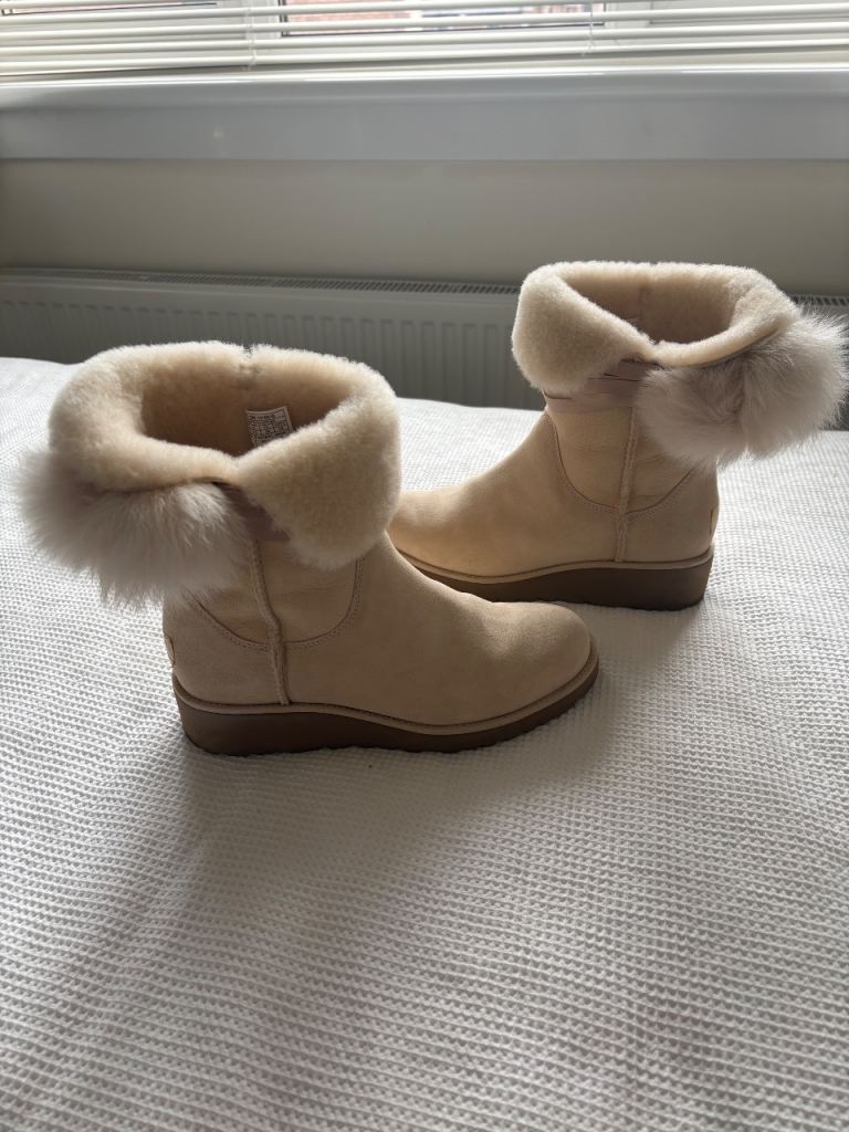 Ladies cream Ugg sheepskin ankle boots with pom-poms. 