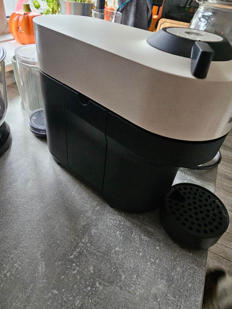 Nespresso veturo pod coffee maker machine in white with Nespresso cups/saucers, storage jar and pods