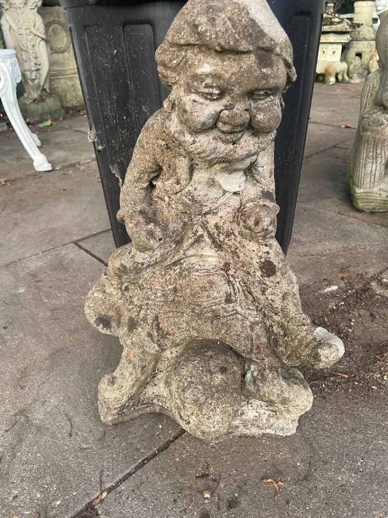 Concrete garden gnome riding tortoise 