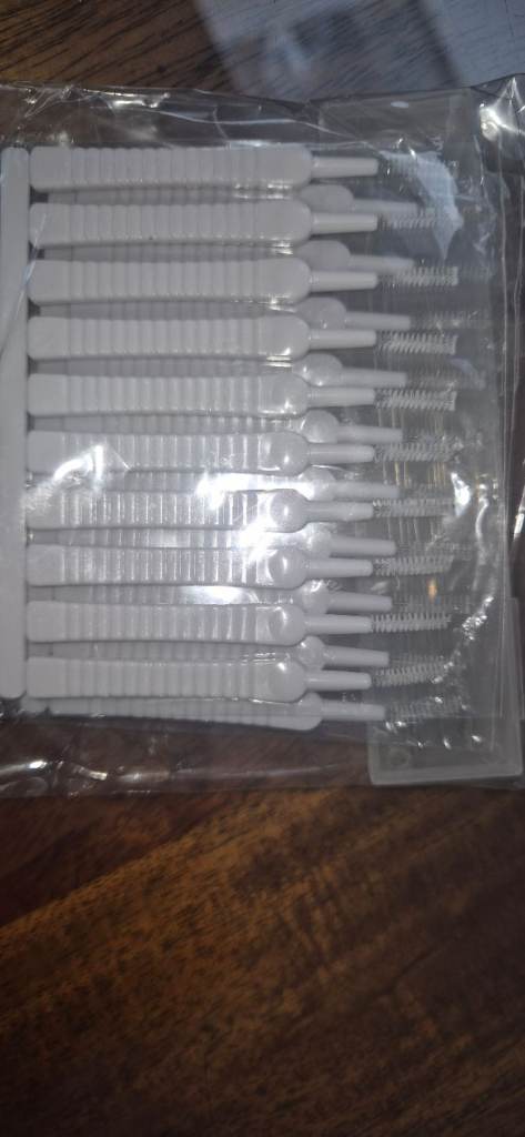 Interdental brushes with floss sticks
