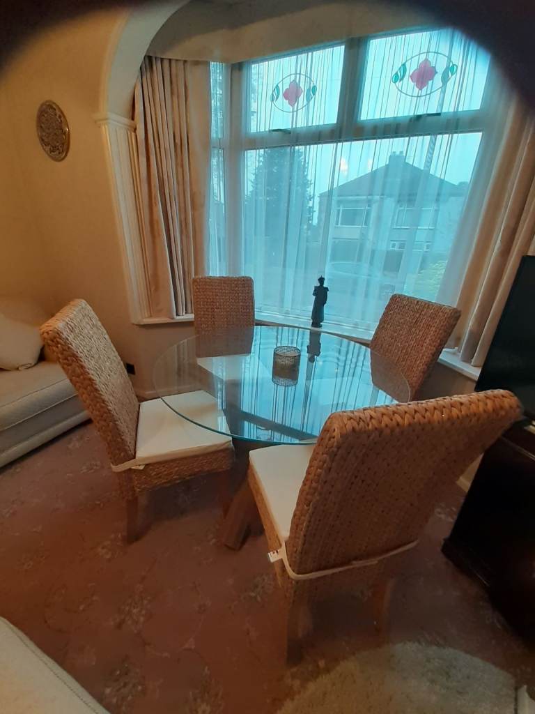 DINING TABL,E GLASS TOP & 4 HIGH BACK RATTAN CHAIRS WITH CUSHIONS