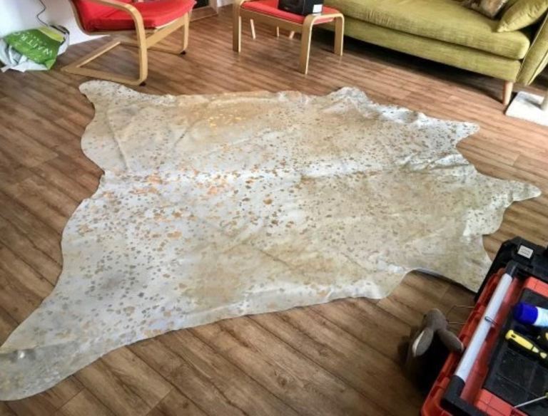 Natural and gold speckled cow hide rug