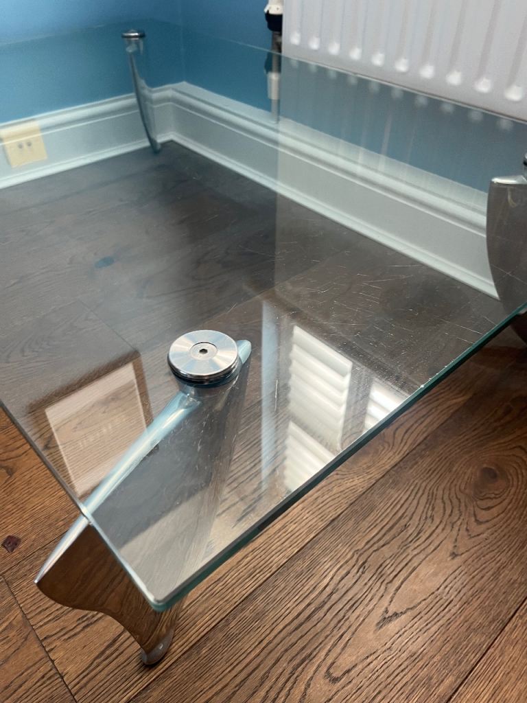 Glass table with aluminium legs shape of shark fin, design by Matthew Hilton