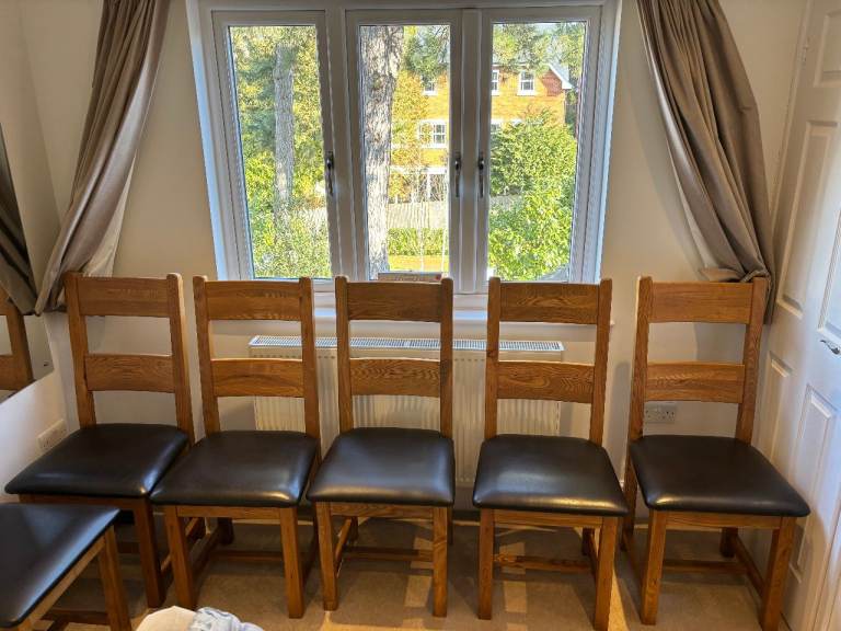 Beautifully made set of six solid oak dining chairs with sleek black leather seats