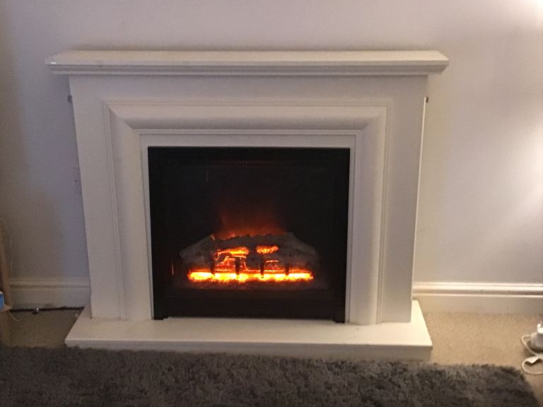 White electric log effect fire and surround unit.