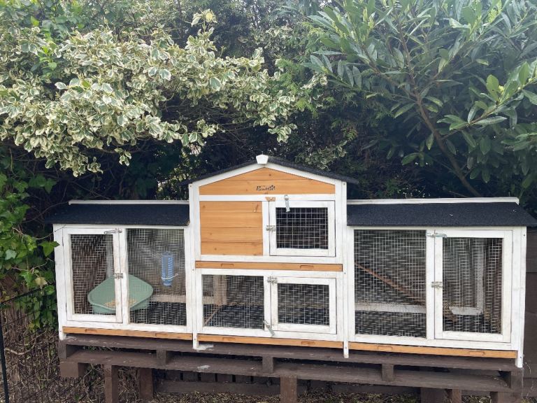 A large rabbit hutch with accessories. 