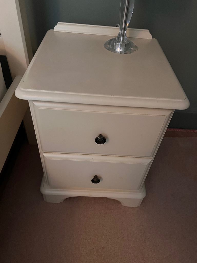 Two cream wooden bedside tables