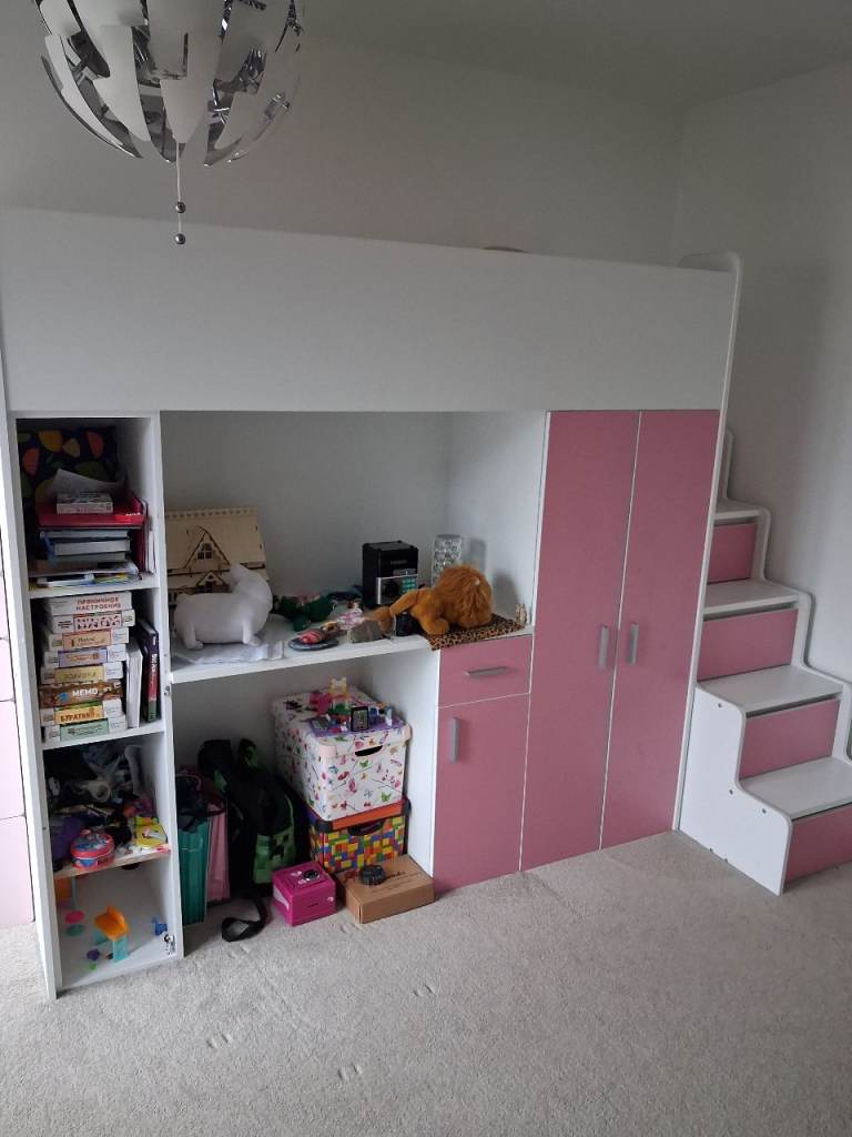 Girl's bunk bed with storage units and a desk.