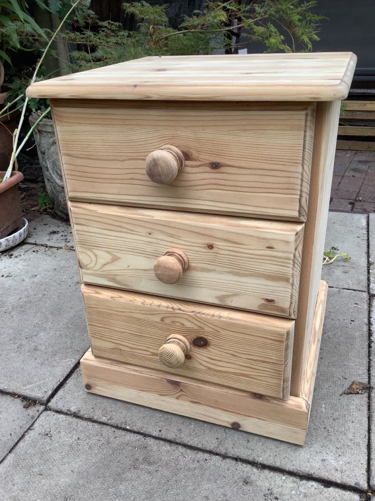  Modern pine three drawer bed side unit with wooden handles 