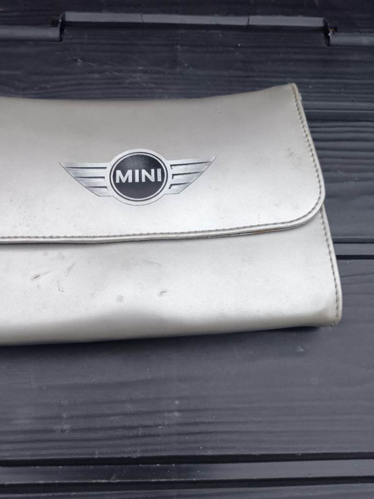 Mini owners hand, service book with wallet