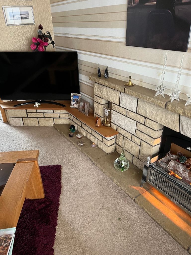 Cotswold stone fireplace complete with fire and surrounding stone 